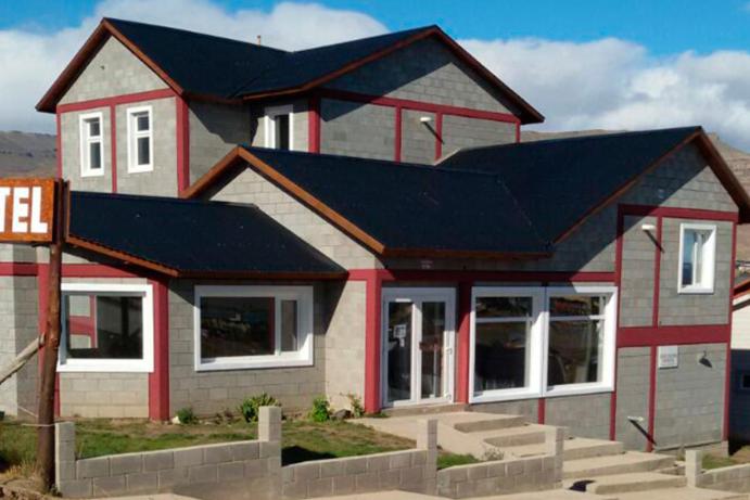 a house with a black roof and red trim at Edelweiss Hostel in El Calafate