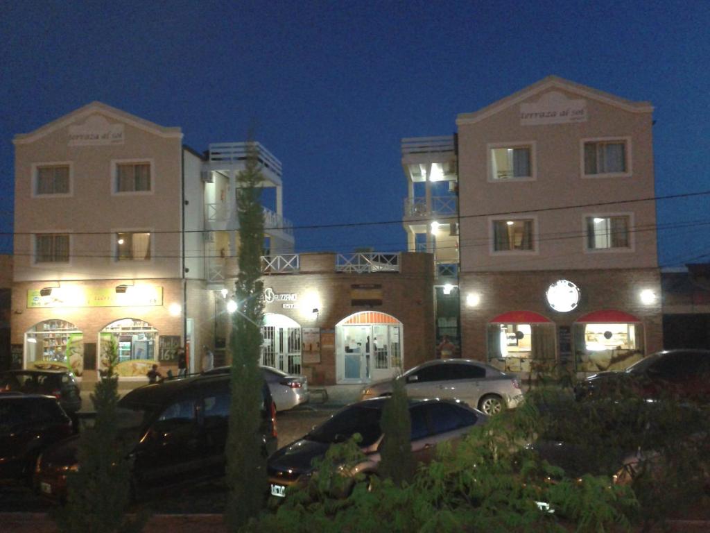 un edificio con coches estacionados en un estacionamiento por la noche en Terraza al Sol en Las Grutas