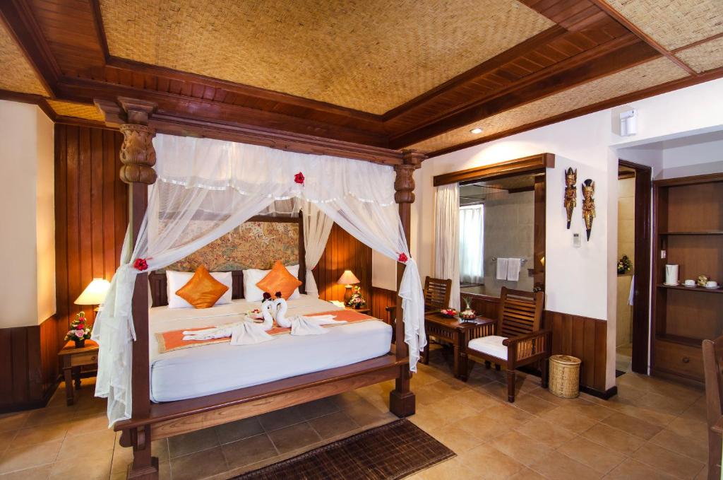 a bedroom with a large bed with a canopy at Sri Phala Resort & Villa in Sanur