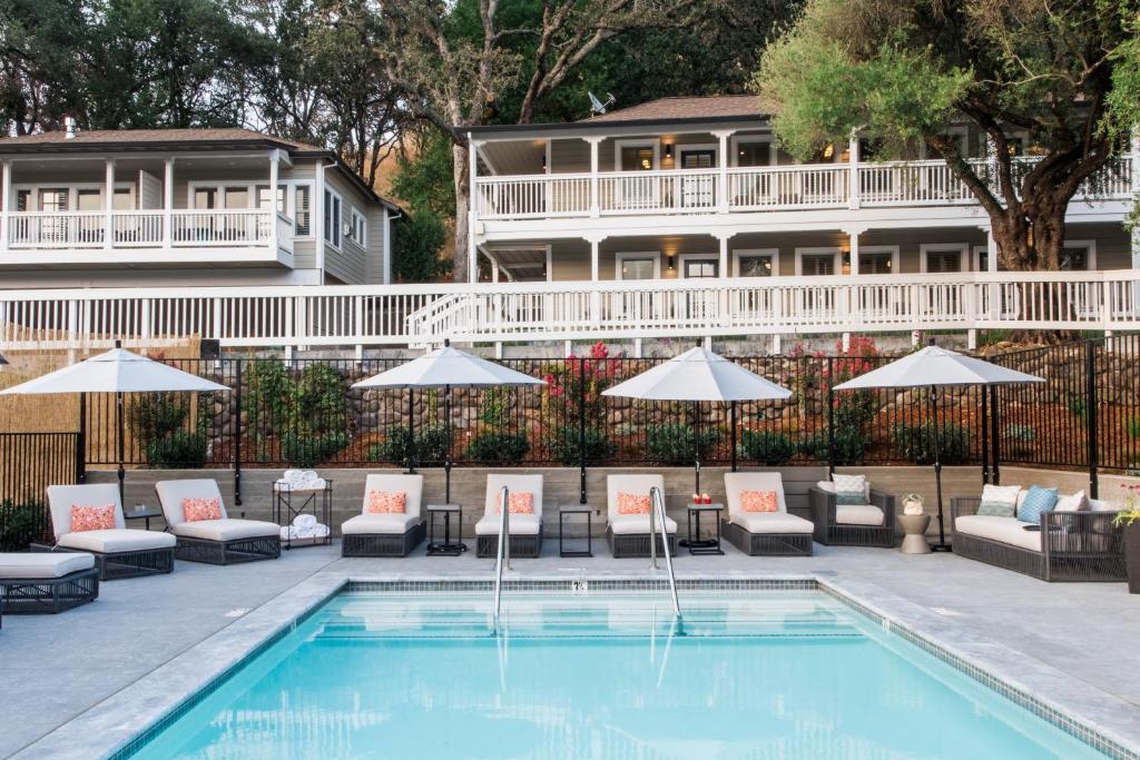 a pool with chairs and umbrellas and a hotel at Olea Hotel in Glen Ellen