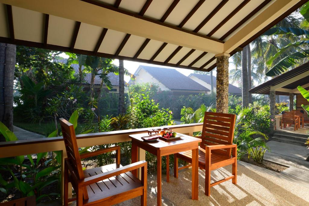a table and chairs on a patio with a view at Cocotinos Sekotong Lombok in Sekotong