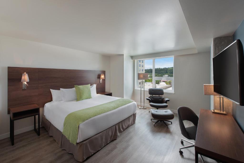 una camera d'albergo con un grande letto e una scrivania di Hotel Interurban Seattle Airport SeaTac a Tukwila