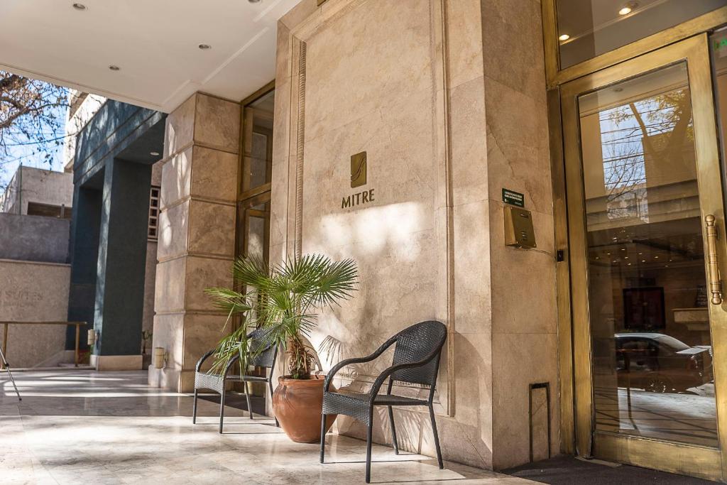 a building with two chairs and a potted plant at Mitre Independent Apart in Mendoza