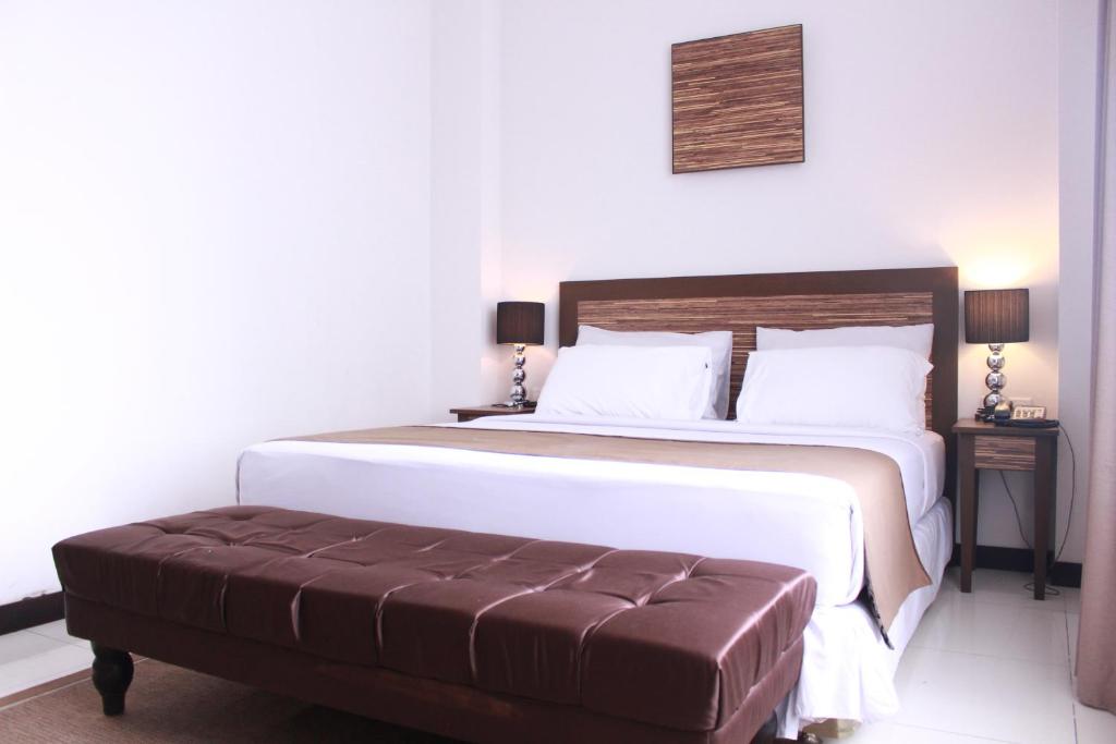 Postel nebo postele na pokoji v ubytování Royal Hotel Bogor