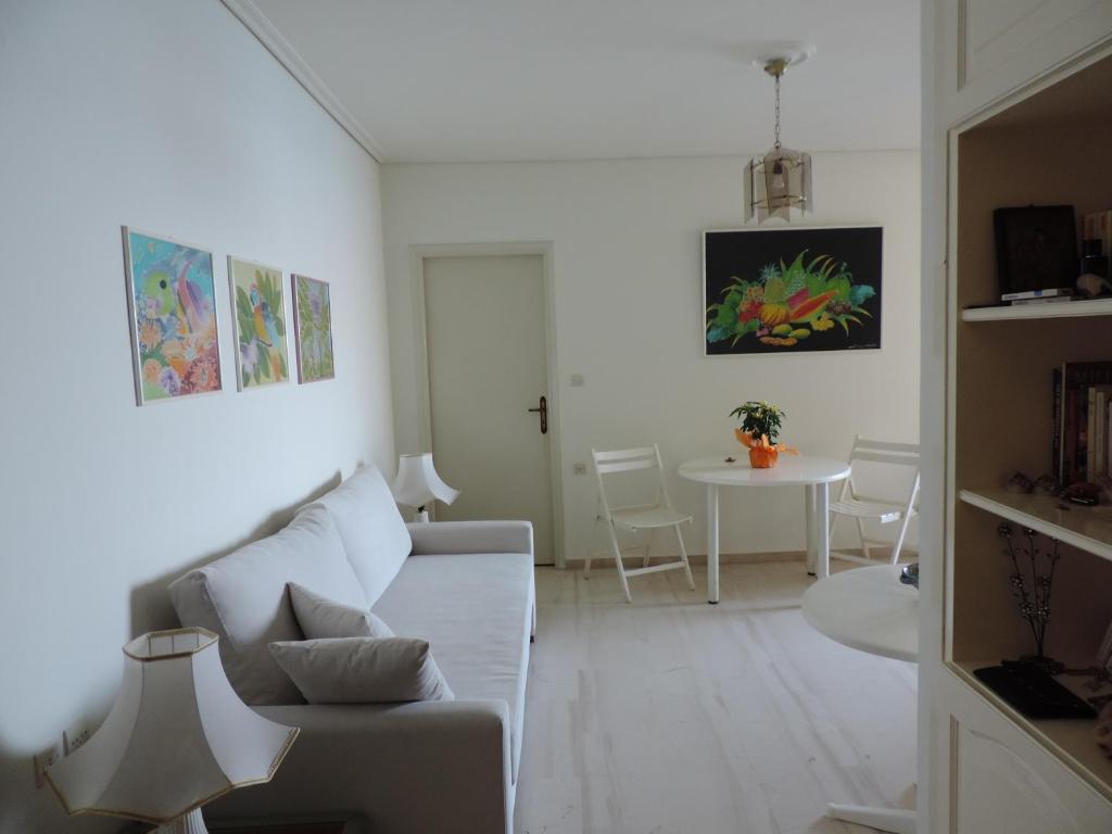 Biały salon z kanapą i stołem w obiekcie Seafront w mieście Karistos