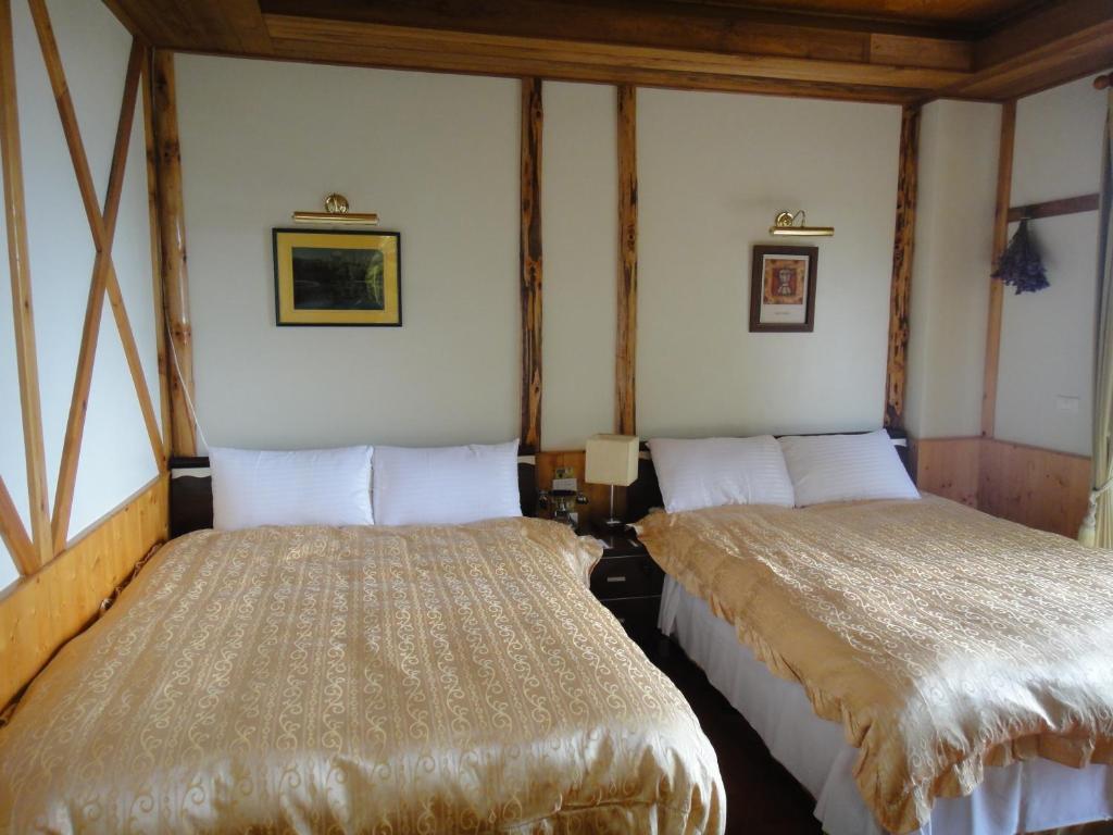 two beds sitting next to each other in a room at Cingjing Vienna Pleasance Cottage in Ren&#39;ai