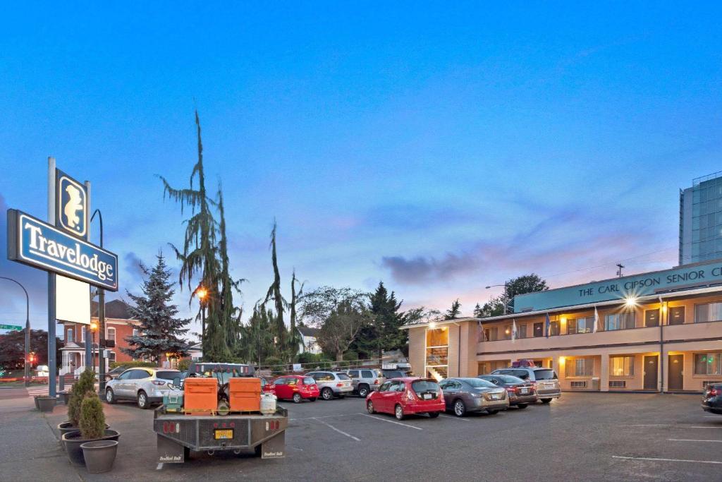 a parking lot with cars parked in front of a hotel at Travelodge by Wyndham Everett City Center in Everett