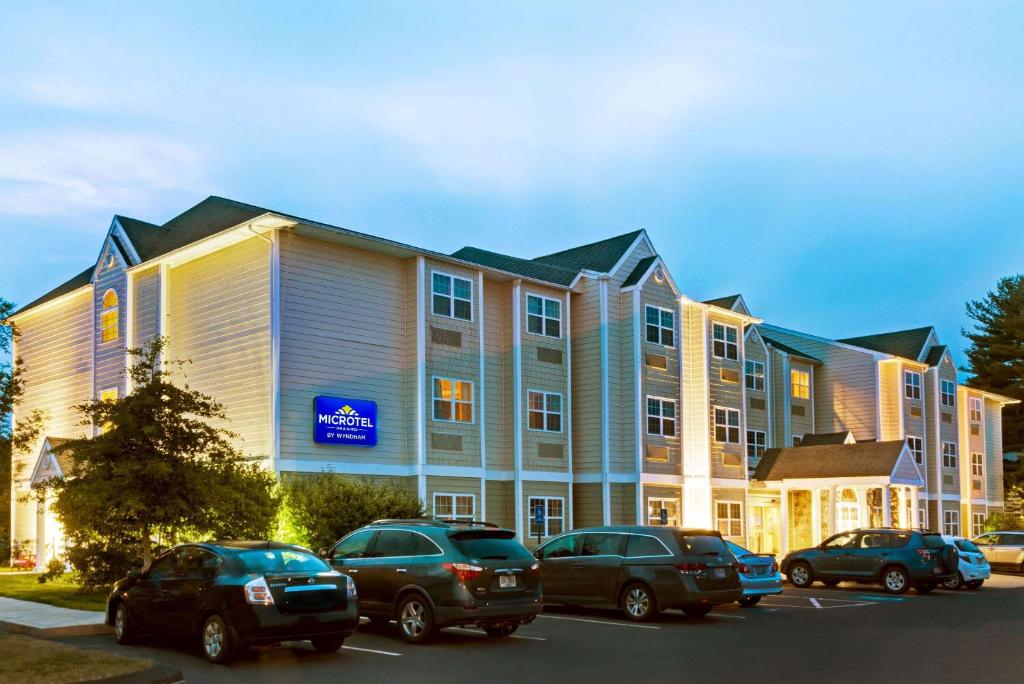 un gran edificio con coches estacionados en un estacionamiento en York Microtel Inn & Suites by Wyndham, en York