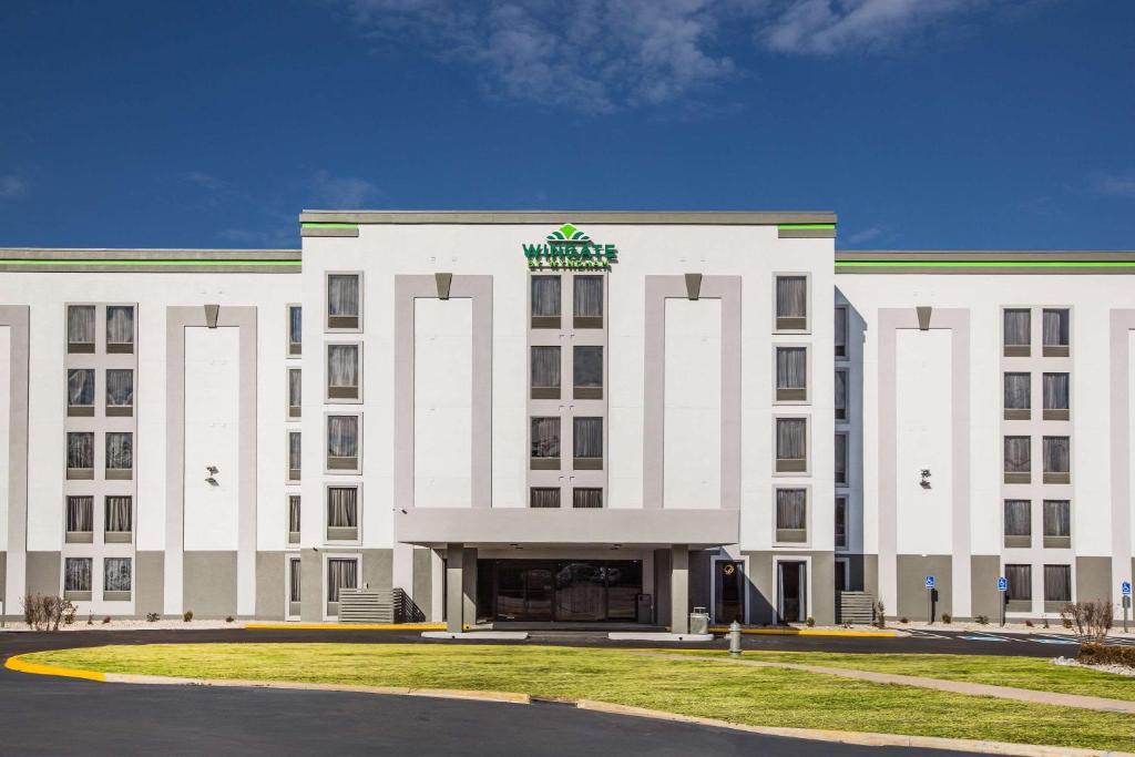 un edificio blanco con un cartel encima en Wingate by Wyndham Louisville Airport Expo Center, en Louisville