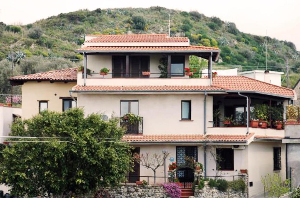une grande maison blanche avec une colline en arrière-plan dans l'établissement B&B Ulisse, à Roccella Ionica