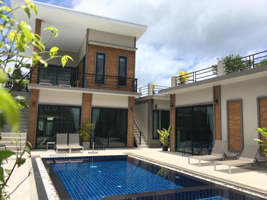 a villa with a swimming pool and a house at Baan Fran Sim Da in Bang Tao Beach