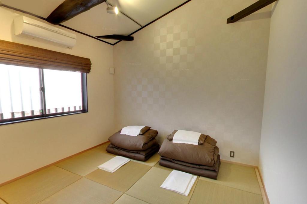 a living room with two couches and a window at Kyoto Guesthouse Roujiya in Kyoto