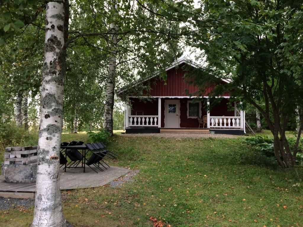 una casa roja con una mesa de picnic en un patio en Rissalan Lomamökit en Juankoski