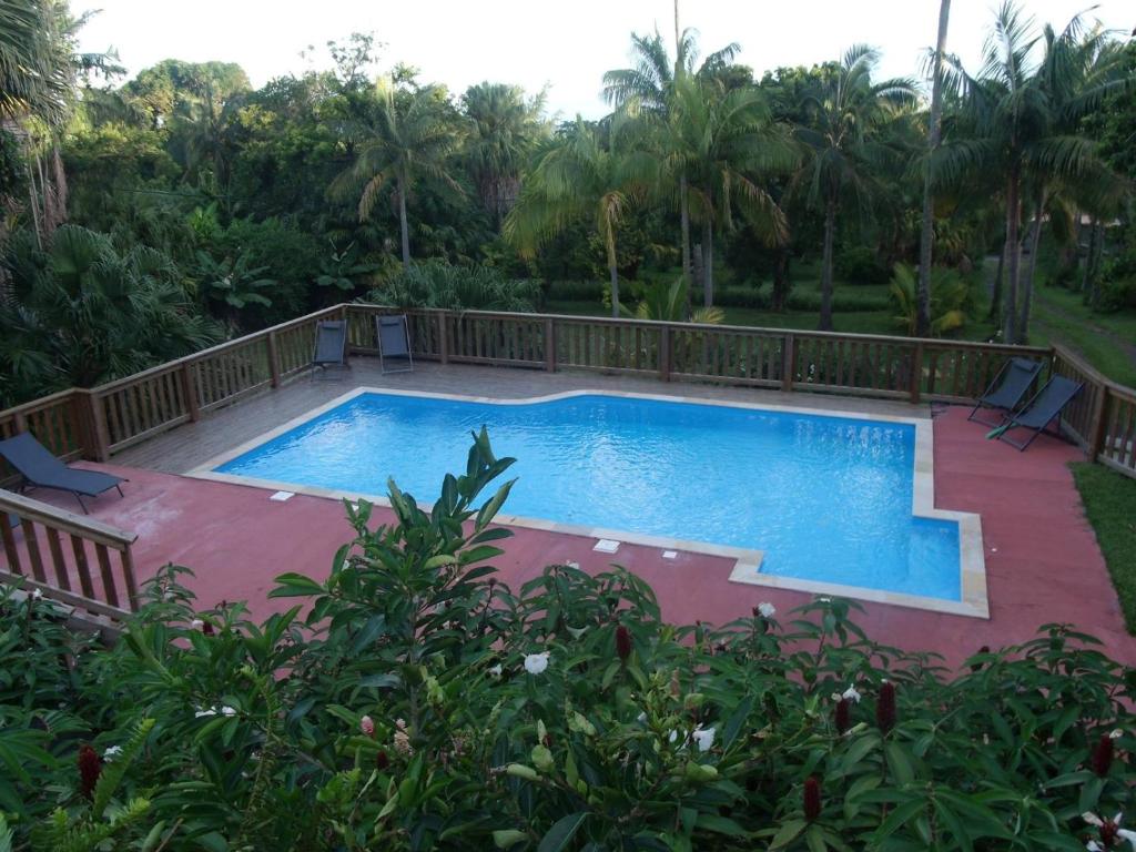 a large swimming pool with a wooden fence around it at Le four à pain in Saint-Philippe