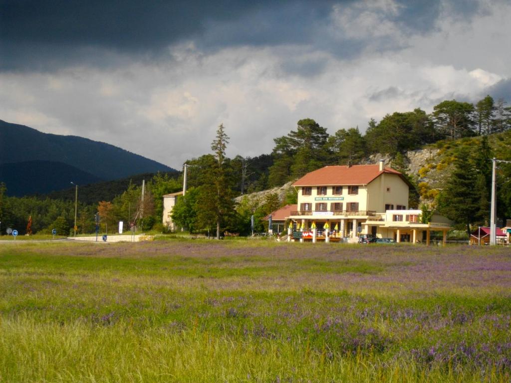 a house in a field with a field of purple flowers at Le Relais de l'Artuby in Séranon