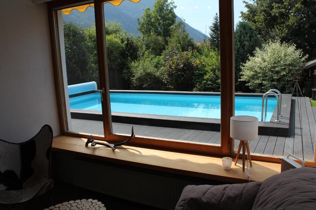 uma janela com vista para uma piscina em Haus am Pool - Wohlfühloase em Ohlstadt