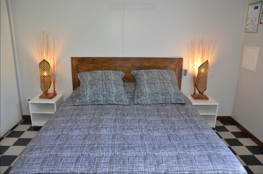 a bedroom with a bed with pillows and two lamps at Le four à pain in Saint-Philippe