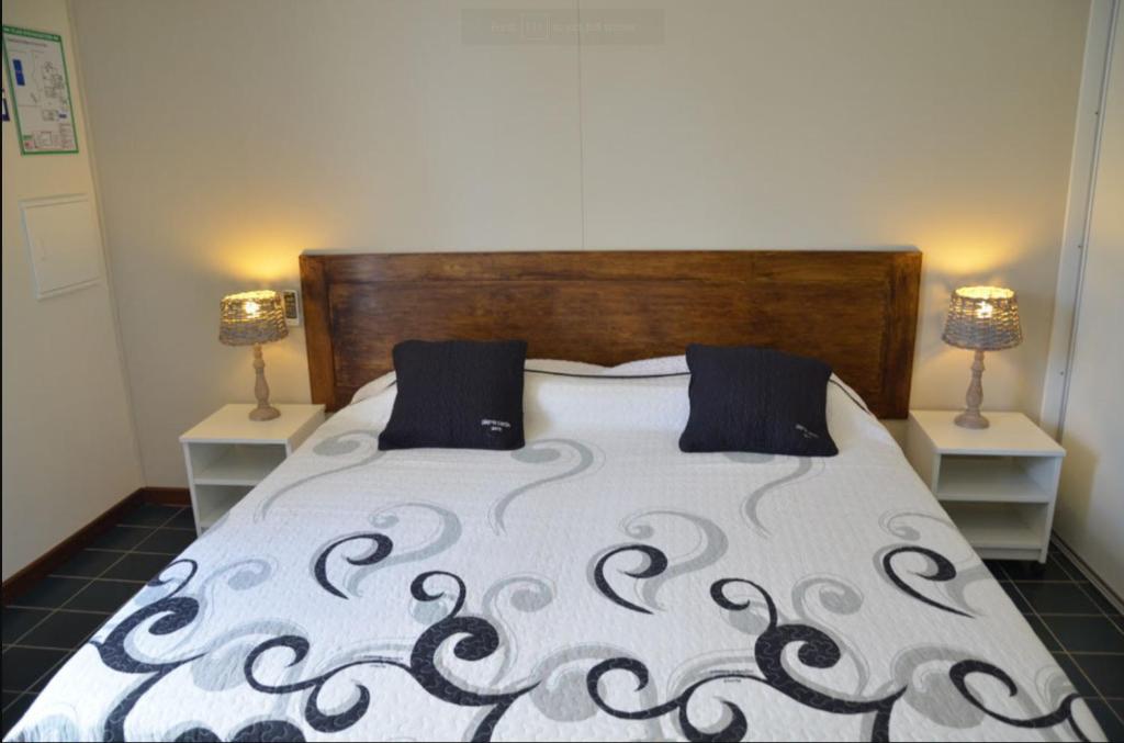 a bedroom with a bed with a black and white comforter at Le four à pain in Saint-Philippe