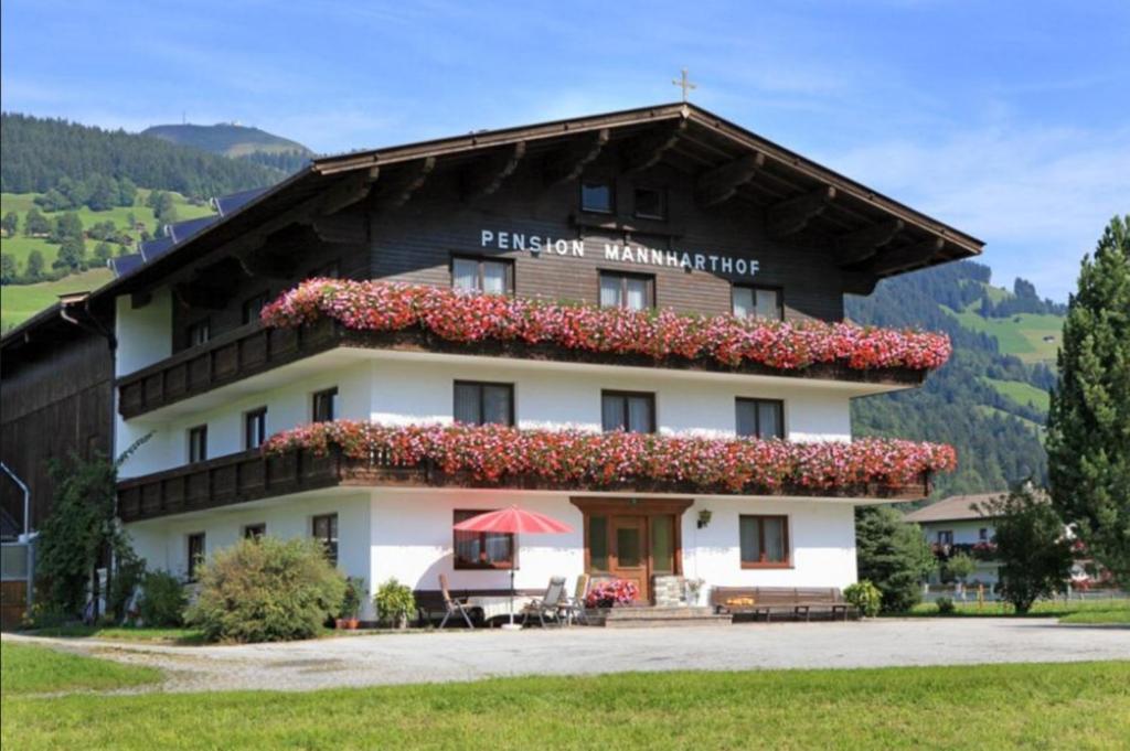 a building with flowers on the top of it at Pension Mannharthof in Westendorf