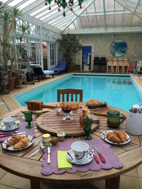 a table with food on it in front of a swimming pool at Maison du Théâtre Saint Bonnet in Bourges
