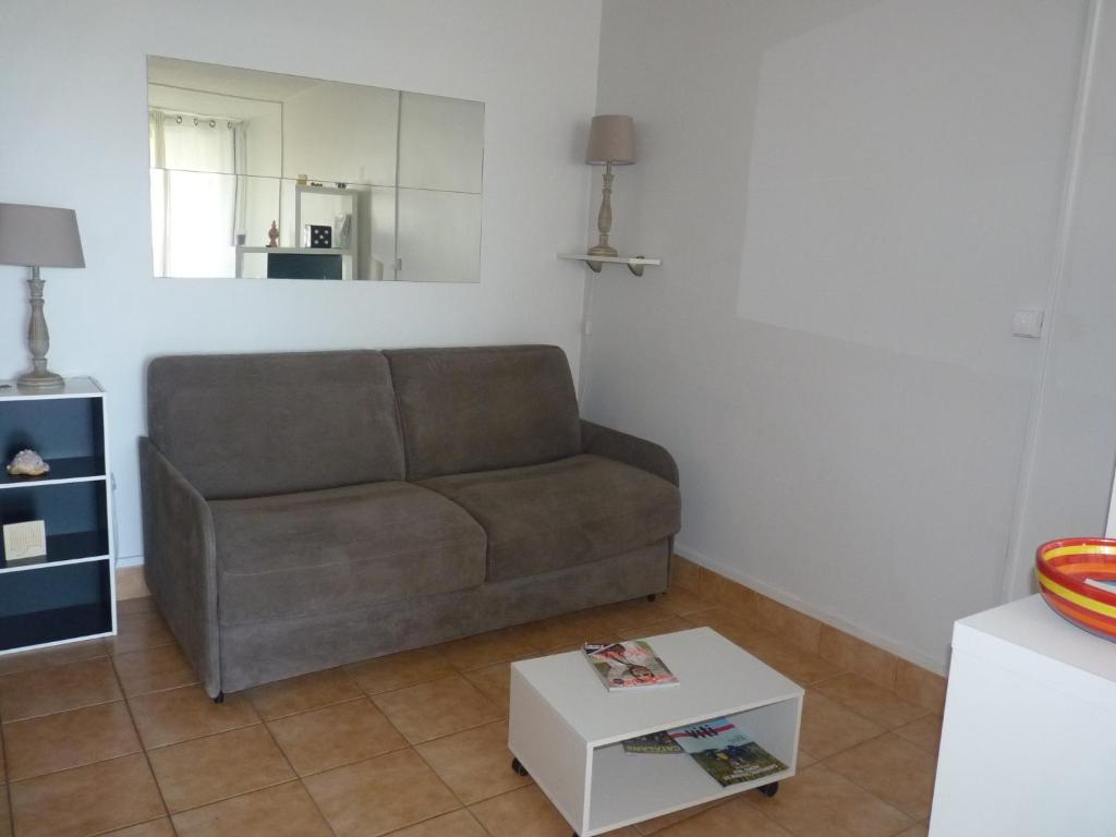 a living room with a couch and a table at Appartement T2 RDC, Front de Mer, 4 couchages, Les Balcons de la Méditerranée Narbonne Plage in Narbonne-Plage