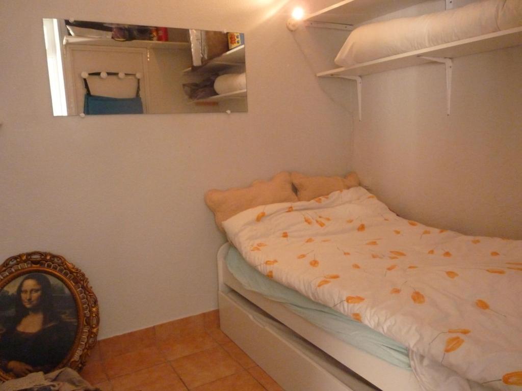 a small bedroom with a bed and a mirror at Appartement T2 RDC, Front de Mer, 4 couchages, Les Balcons de la Méditerranée Narbonne Plage in Narbonne-Plage