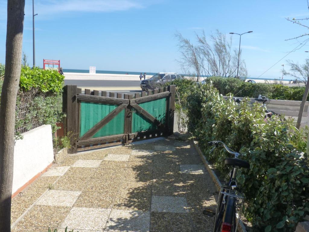 a bike is parked in front of a gate at Appartement T2 RDC, Front de Mer, 4 couchages, Les Balcons de la Méditerranée Narbonne Plage in Narbonne-Plage