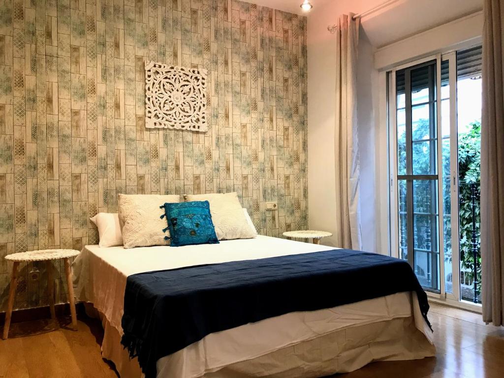 een slaapkamer met een bed en een muur bij Triana Luxury Home in Sevilla