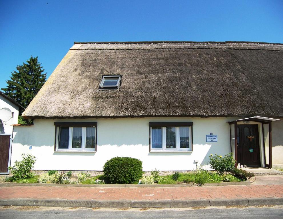 a white house with a thatched roof at Reethaus Natalie in Korswandt
