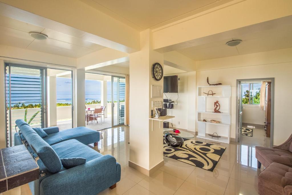 a living room with a blue couch and a table at Mai'i Villa Apartment - 1 in Titikaweka