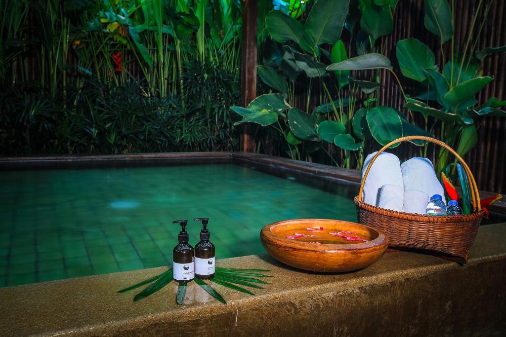 a basket of eggs and two bottles of beer next to a swimming pool at Azalea Village in Chiang Dao