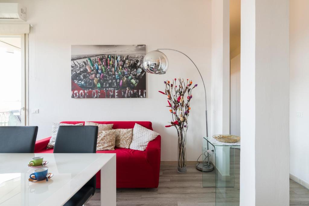 een woonkamer met een rode bank en een tafel bij Visarno Arena Apartment in Florence