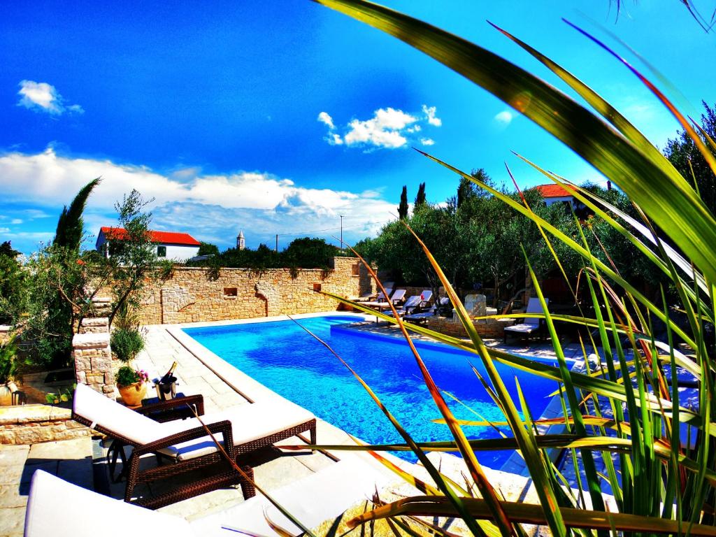 a swimming pool with two lounge chairs next to it at Villa Kos Murter Apartments in Murter
