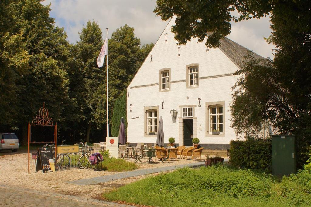 une maison blanche avec un drapeau devant elle dans l'établissement Het Kapelhuis, à Thorn