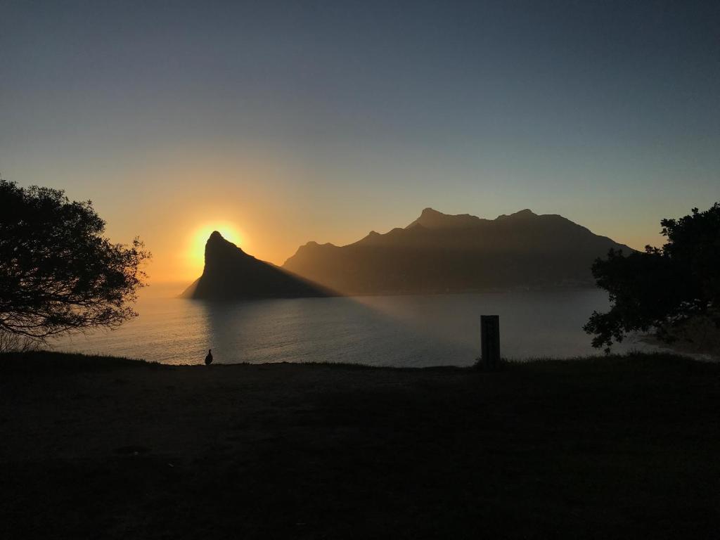 a sunset over a body of water with a mountain at The Loft in Hout Bay