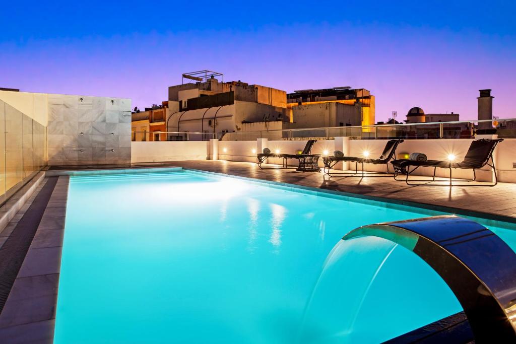 a swimming pool on the roof of a building at One Shot Palacio Conde de Torrejón 09 in Seville