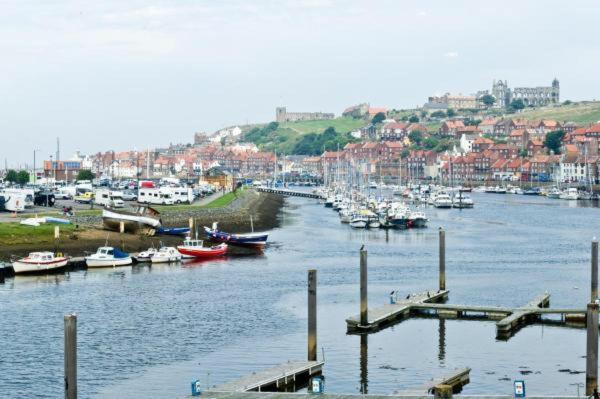 a marina with boats in the water and a town at Watermark Apartments in Whitby