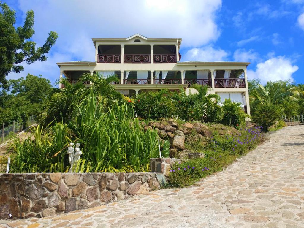 una casa en la cima de una colina con una carretera en Villa Touloulou, en English Harbour Town