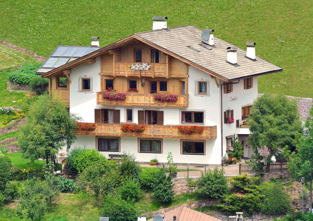 a large house with a balcony on a hill at Penthouse-Apartment Limbela in Ortisei