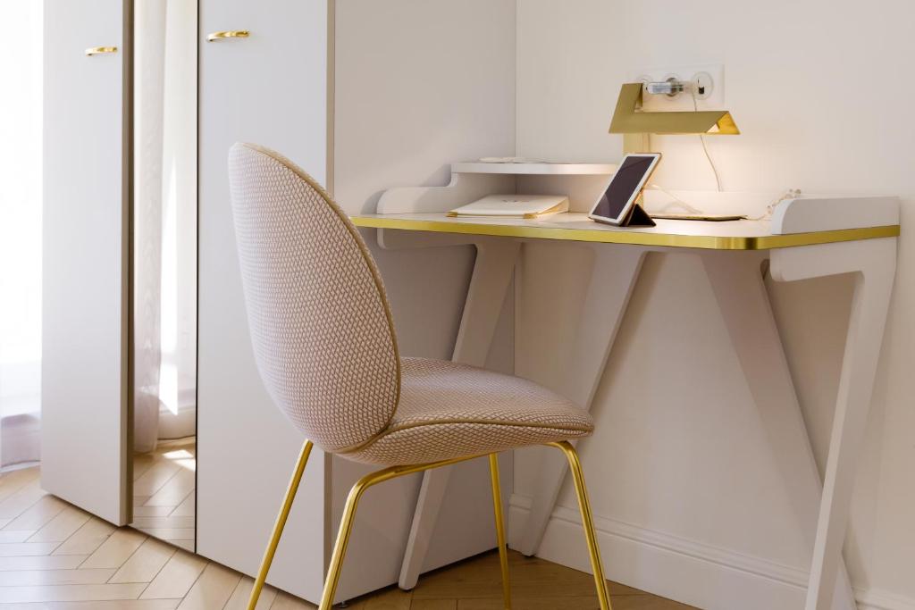 a desk with a chair and a laptop on it at Hôtel le XIX in Béziers