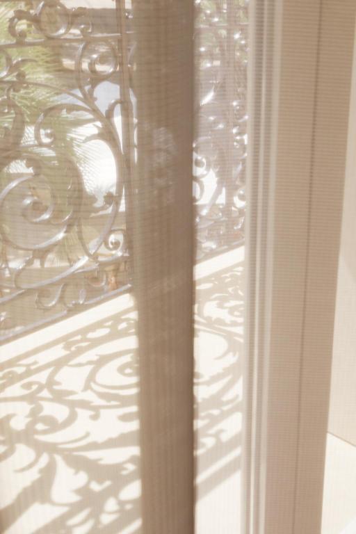 a window with a metal railing on a balcony at Hôtel le XIX in Béziers