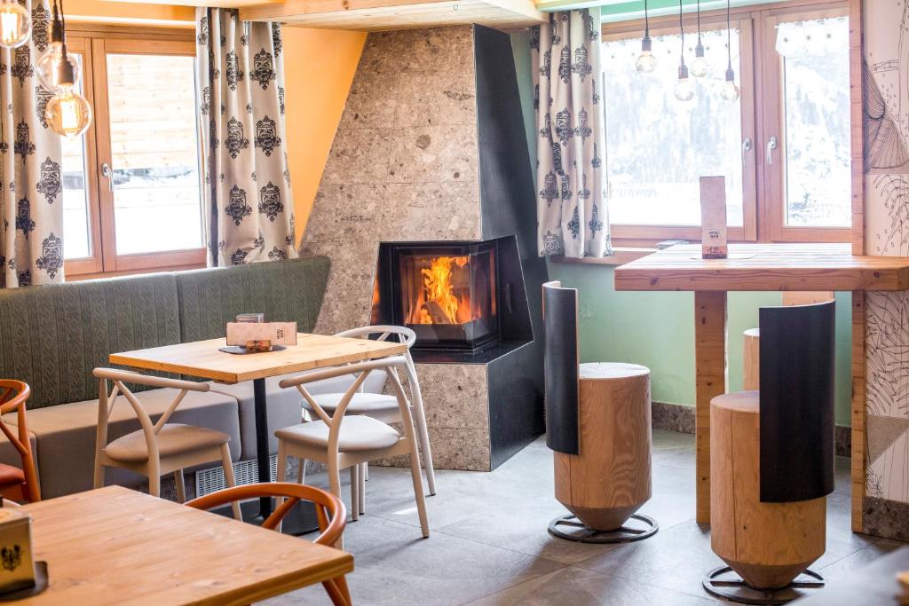 a fireplace in a restaurant with tables and chairs at Rifugio La Montanara in Molveno