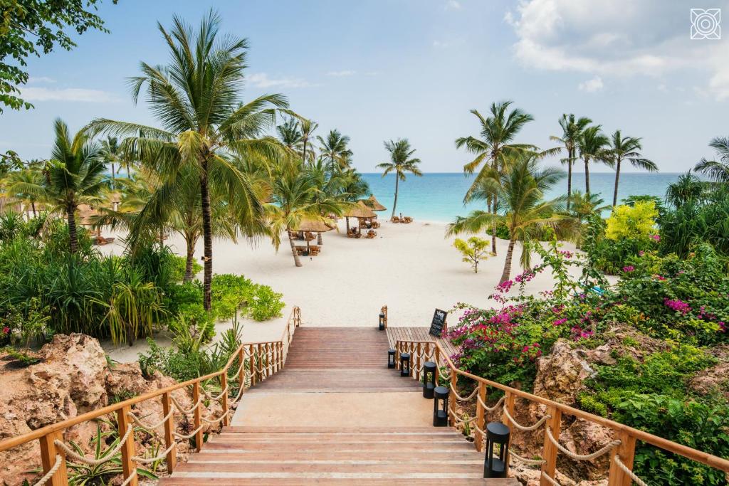 a stairway to the beach with palm trees and the ocean at Zuri Zanzibar in Kendwa