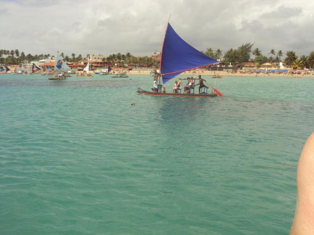 un grupo de personas en un pequeño velero en el agua en Flat Beira Mar Praia Ponta Negra, en Natal