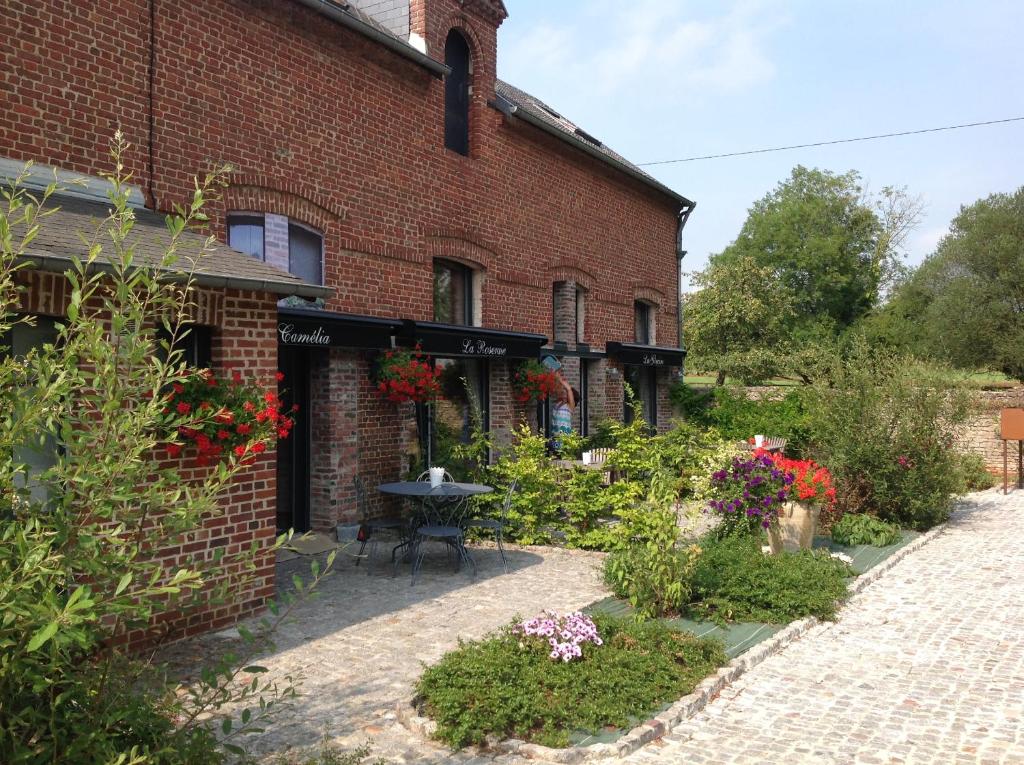 a brick building with a garden in front of it at Gîtes de la maison du haras in Beuvron-en-Auge
