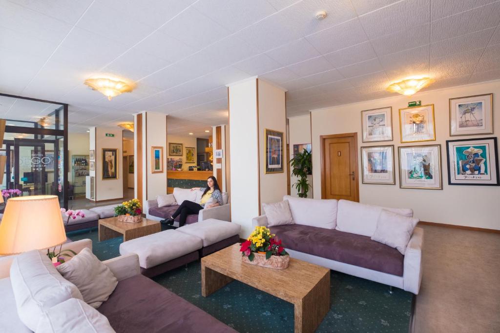 a woman is sitting in a living room at Ilgo Hotel in Perugia