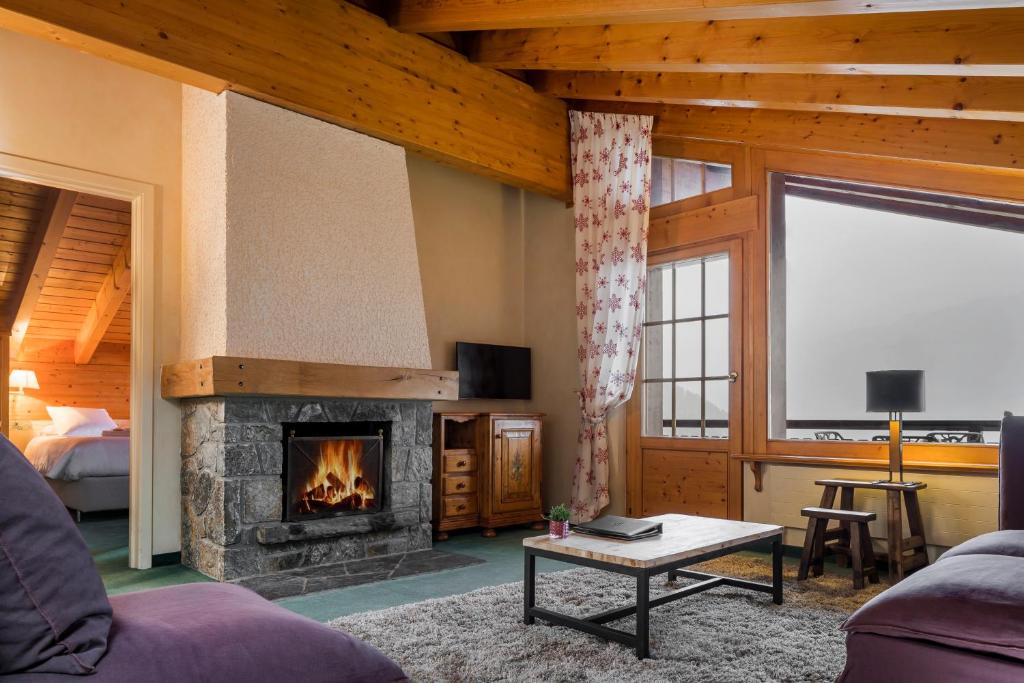 a living room with a fireplace and a bed at Hotel Montpelier in Verbier