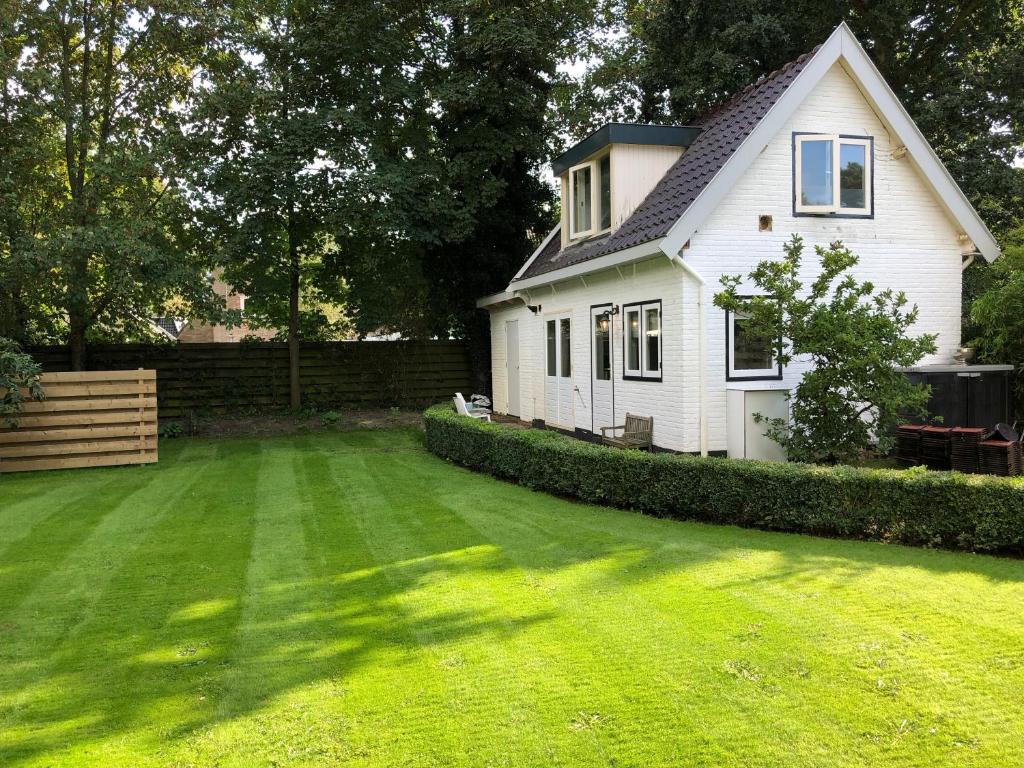 a white house with a yard with a green lawn at Blossom in Bergen
