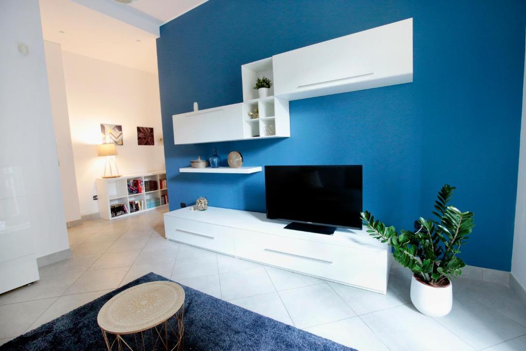 sala de estar con TV y pared azul en Quater Apartments - Milano en Milán
