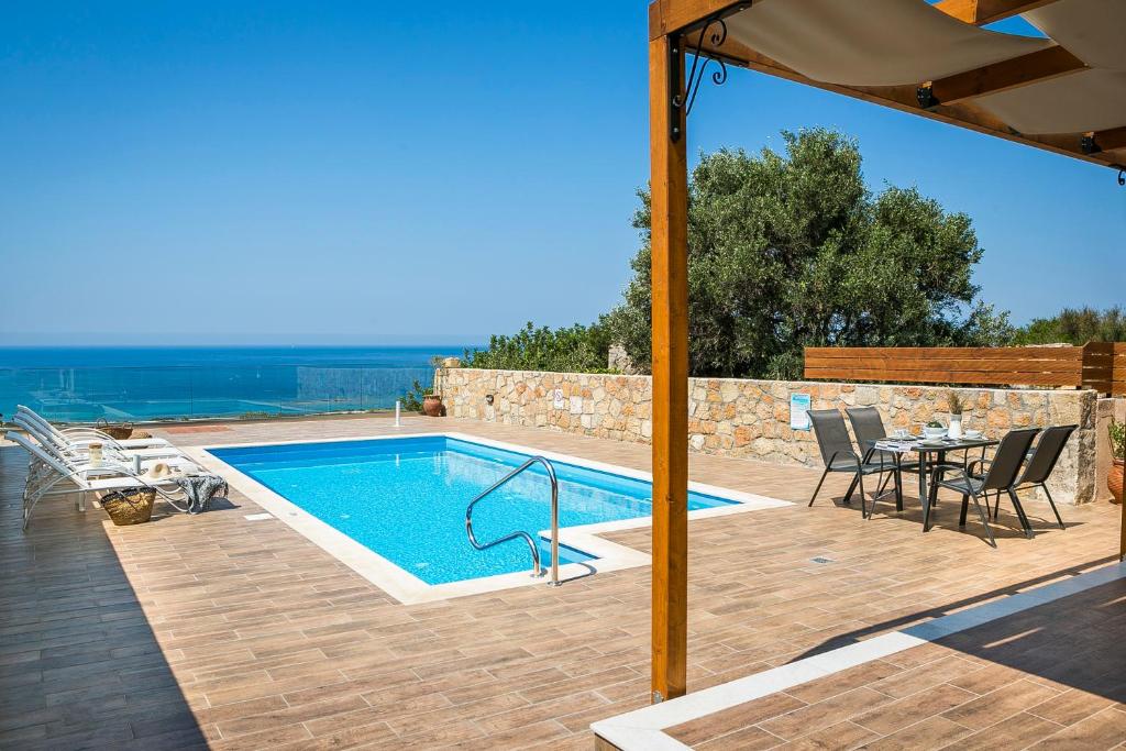 a swimming pool with a table and chairs and an umbrella at Villa SeaBreeze in Minia